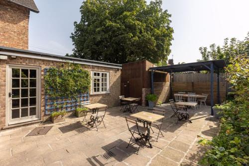 a patio with tables and chairs and a black umbrella at The Dawnay Arms in West Heslerton