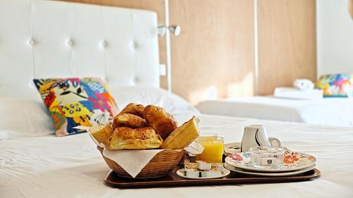 a tray of bread and pastries on a bed at Hotel Le Florian in Cannes