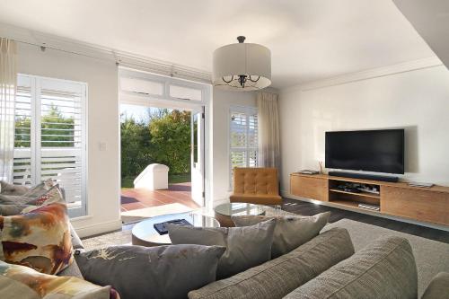 ein Wohnzimmer mit einem Sofa und einem Flachbild-TV in der Unterkunft Winelands Golf Lodges 3 in Stellenbosch