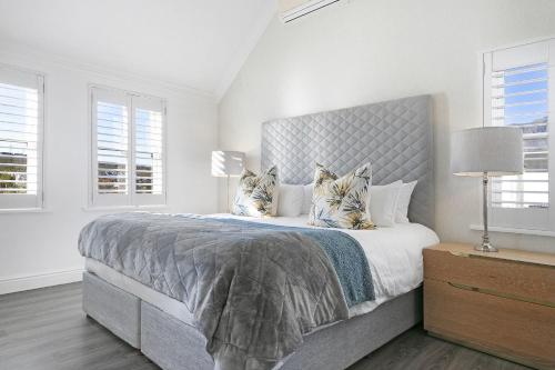 ein Schlafzimmer mit einem großen Bett und zwei Fenstern in der Unterkunft Winelands Golf Lodges 3 in Stellenbosch