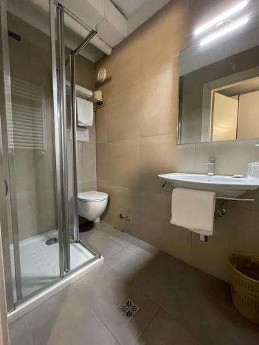 y baño con ducha, aseo y lavamanos. en Hotel Albatros, en Mestre