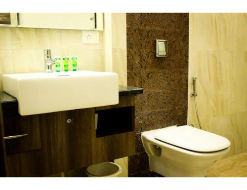 a bathroom with a white sink and a toilet at Hotel Sobti Plaza, Ambala, Haryana in Ambāla