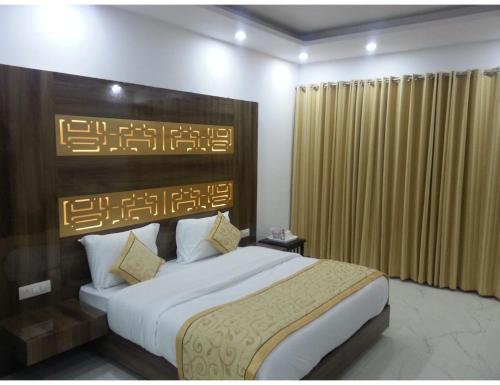 a bedroom with a large bed with a wooden headboard at Hotel Sobti Plaza, Ambala, Haryana in Ambāla