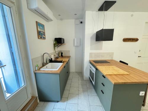 une cuisine avec un évier et un plan de travail dans l'établissement Le ROUSTAN - Halles à 2 mins - WIFI - CLIM, à Sète
