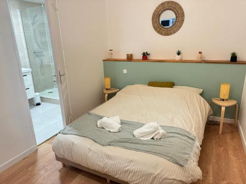 une chambre avec un lit avec deux serviettes dessus dans l'établissement Le ROUSTAN - Halles à 2 mins - WIFI - CLIM, à Sète