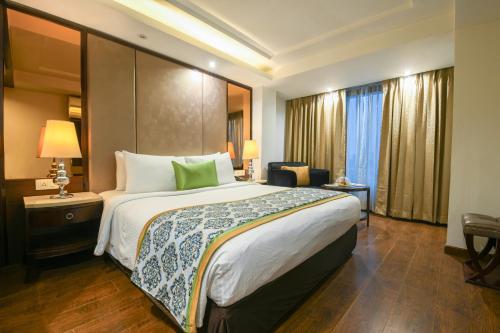 a hotel room with a large bed and a chair at Flute Boutique by Hotel 91 in Jaipur