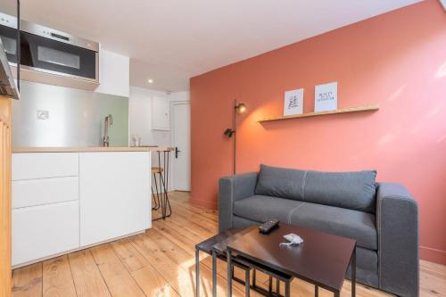 un salon avec un canapé et une cuisine dans l'établissement Little duplex in République beaux arts, à Lille
