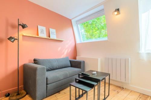 un salon avec un canapé et une table dans l'établissement Little duplex in République beaux arts, à Lille