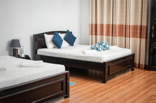 twee bedden in een kamer met houten vloeren bij ESSPEEDY Hill Forest Cottages and Yoga Centre in Ella