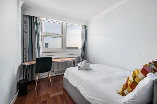 una camera con letto, scrivania e finestra di Two Stunning Bedrooms & Private Balcony & River View a Londra
