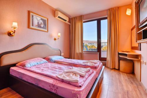 sypialnia z łóżkiem i dużym oknem w obiekcie Luxury Apartment Zlatna Kotva w Złotych Piaskach