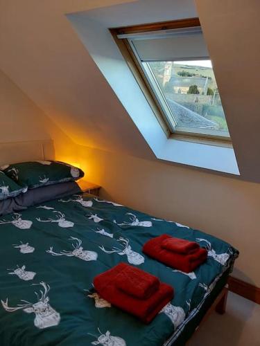 a bedroom with a bed with two red towels on it at Top Floor Flat Ceol Na Mara (Music of the Sea) in Rosemarkie