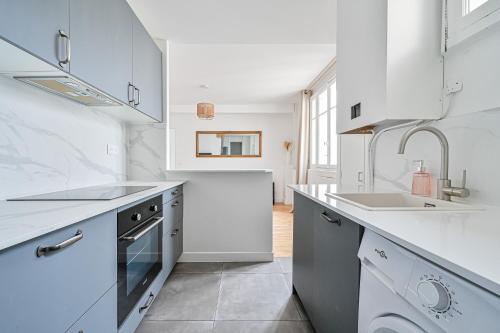 une cuisine blanche avec un évier et une cuisinière dans l'établissement CityStay-Confort- 5 min Metro -, à Boulogne-Billancourt