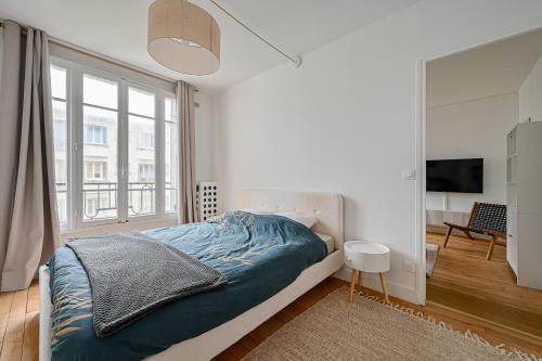 a bedroom with a bed and a large window at CityStay-Confort- 5 min Metro - in Boulogne-Billancourt