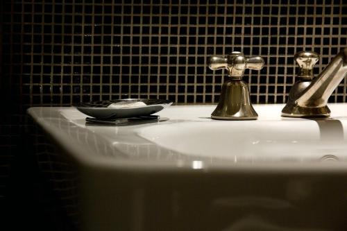 a bathroom sink with a plate and a faucet on it at Marcella Royal Hotel - Rooftop Garden in Rome