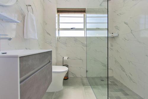 a bathroom with a toilet and a glass shower at Retro Rest - walking distance to Beach, Langebaan in Langebaan