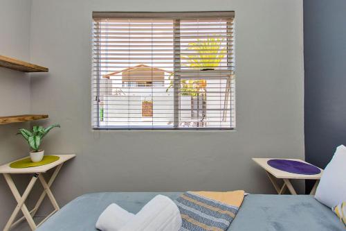 a room with a bed and a window and a chair at Retro Rest - walking distance to Beach, Langebaan in Langebaan