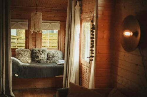 Zimmer mit einem Bett in einem Blockhaus in der Unterkunft A magical get away with bath and forest view in Putten