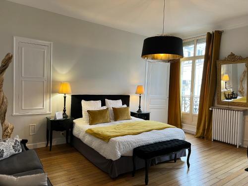 a bedroom with a large bed with a yellow blanket at La Demeure des Sacres - Cathédrale in Reims