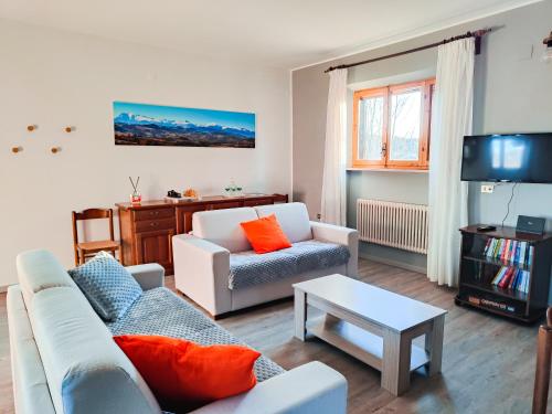 a living room with two couches and a tv at [vista Sibillini] Villa Amici in Verri