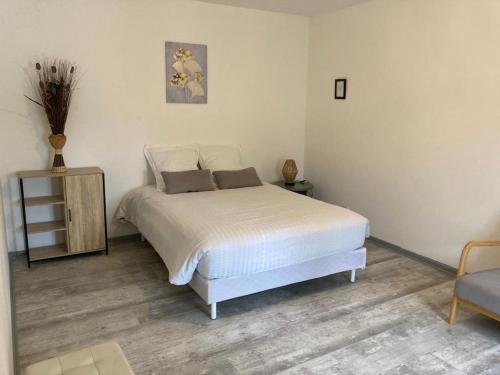 una camera con un letto bianco e una sedia di Apt 2 pièces Cosy Le Rimbaud a Charleville-Mézières