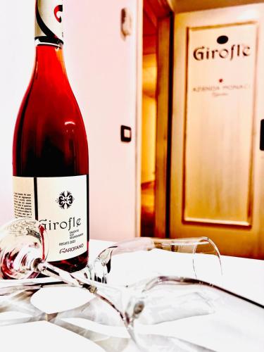a bottle of wine sitting on a table with glasses at Relais Porta del Sud in Ostuni