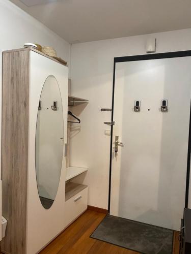 - une salle de bains avec un miroir à côté d'une porte dans l'établissement Rez de jardin - JO 2024, à Plaisir