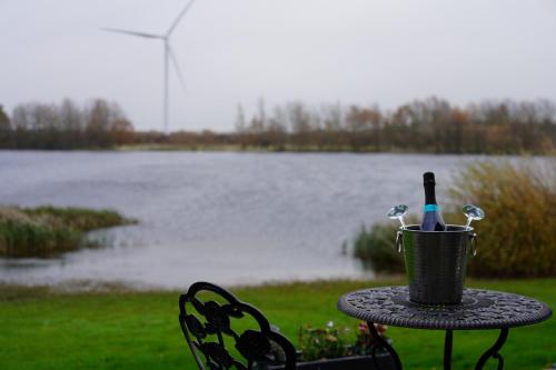 a table with a basket with a bottle and a wine glass at The Angel - Luxury Lakeside Lodge in Cotham