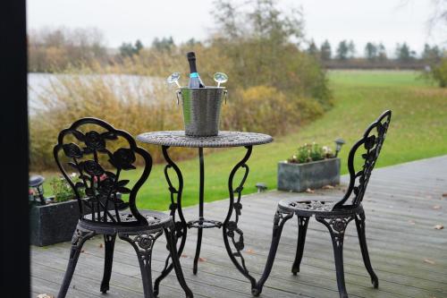 a table and two chairs on a deck at The Angel - Luxury Lakeside Lodge in Cotham