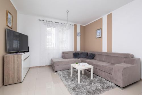 a living room with a couch and a table at Modern Apartment with Parking in Cracow by Rent like home in Kraków