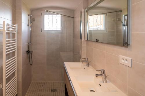 een badkamer met 2 wastafels, een spiegel en een douche bij Rez de Villa La Belle Californienne in Carqueiranne