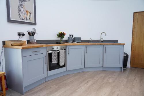 a kitchen with white cabinets and a counter top at The Angel - Luxury Lakeside Lodge in Cotham