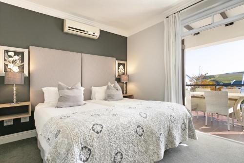 a bedroom with a bed and a large window at Winelands Golf Lodges 24 in Stellenbosch