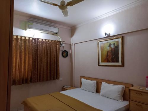 - une chambre avec un lit et une peinture murale dans l'établissement gargi vill guest house, à Pune