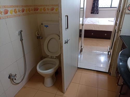 a small bathroom with a toilet and a shower at gargi vill guest house in Pune