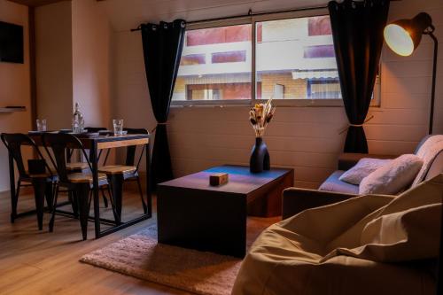 un salon avec une table et un canapé dans l'établissement Ambiance montagne, à deux pas de la gare, à Cluses