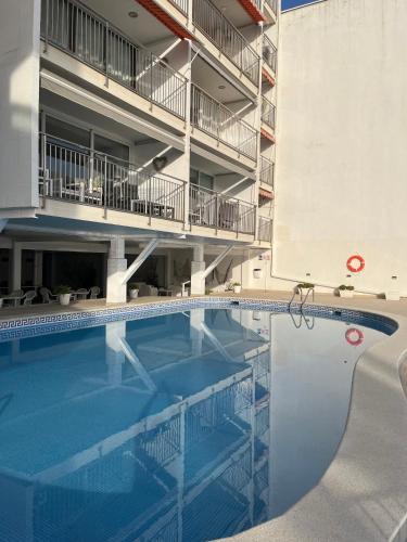 a large swimming pool in front of a building at Beachfront 3-bedroom apartment in Calafell