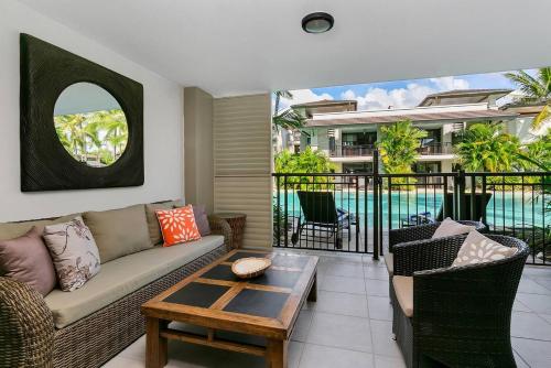 una sala de estar con un sofá y una mesa en 'Aqua Oasis' Swim-out Resort Sanctuary, en Port Douglas