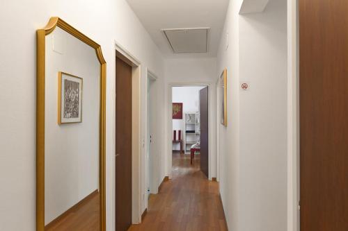 a hallway with white walls and a gold framed mirror at Ca' Lidia - Happy Rentals in Pregassona