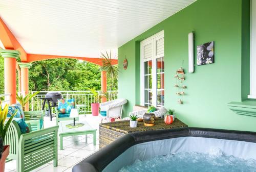 a house with a hot tub on a patio at La maison créole in Rivière-Pilote