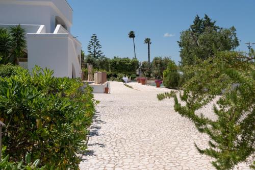 a walkway in front of a building with plants at Relais Porta del Sud in Ostuni