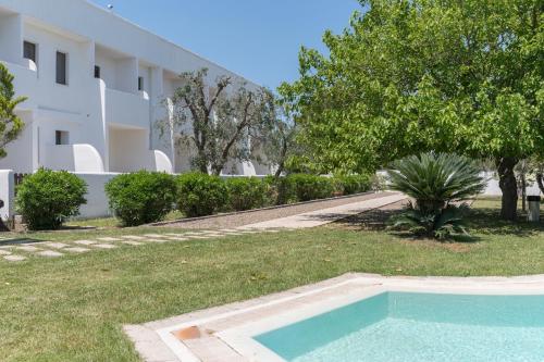 a swimming pool in a yard next to a building at Relais Porta del Sud in Ostuni