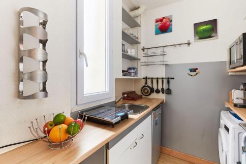 a kitchen with a bowl of fruit on a counter at Montparnasse - Near Saint Germain - CityApartmentStay in Paris