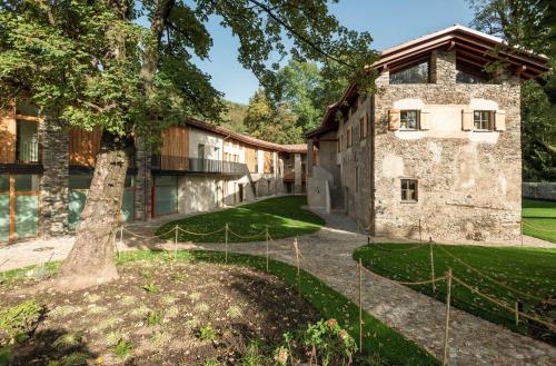 an exterior view of a building with a tree at Locanda della Masseria a Porza, Lugano in Porza