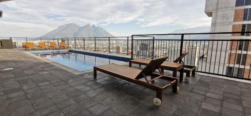 a balcony of a building with a pool and mountains at Depto en el centro de Monterrey. in Monterrey