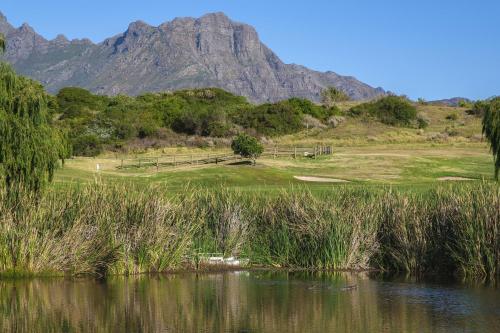 a golf course with a mountain in the background at Winelands Golf Lodges 29 in Stellenbosch