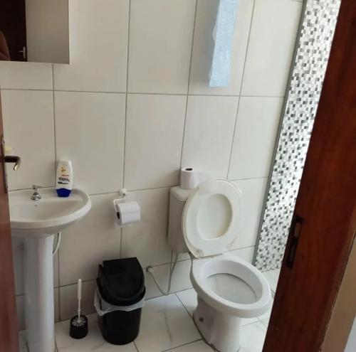 a small bathroom with a toilet and a sink at Casa De Hóspede in Itu