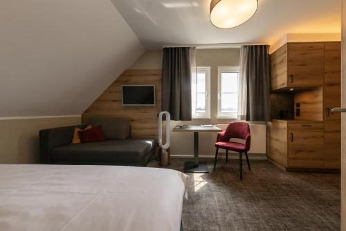 une chambre d'hôtel avec un lit, un canapé et une table dans l'établissement Ringhotel Landhaus Nicolai "Hotel Garni", à Lohmen