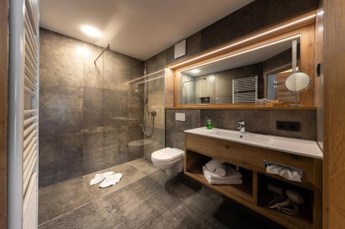 ein Bad mit einem Waschbecken und einem WC in der Unterkunft Ringhotel Landhaus Nicolai "Hotel Garni" in Lohmen