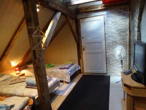a attic room with two beds and a tv at Frendlen Apartmend in Pärnu